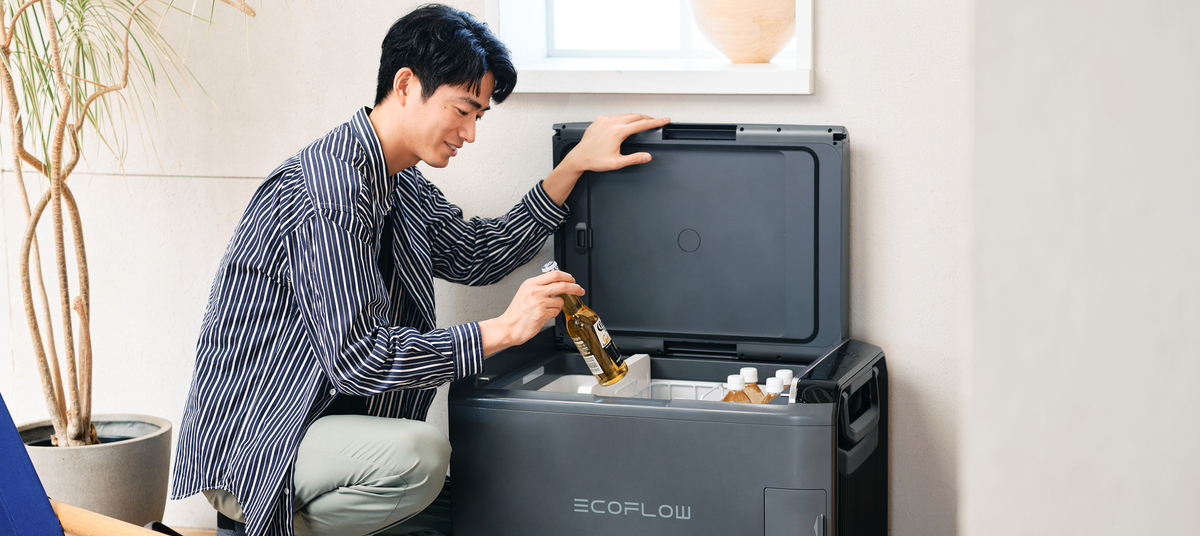 自宅で普段使いするEcoFlow GLACIER Classic 自宅でEcoFlow Glacier Classicポータブル冷蔵庫から飲み物を取り出している男性